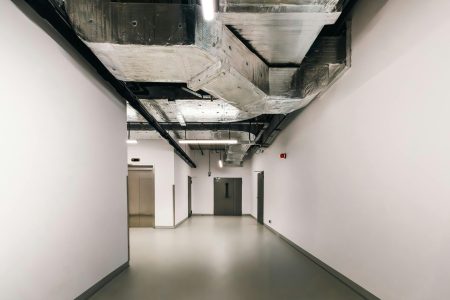 pexels-photo-30749458-30749458 Spacious industrial hallway featuring exposed HVAC ductwork and modern design elements.