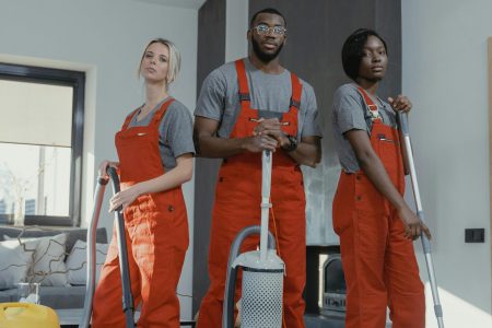 pexels-photo-6195131-6195131 Three cleaners in uniform with equipment in a modern home interior, showcasing teamwork and professionalism.